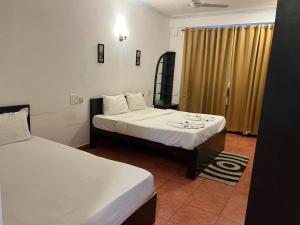 Hotel pleasure inn near turtle beach morjim Manage by ld group of hospitality客房内的一张或多张床位