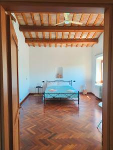 una camera da letto con un letto e un pavimento in legno di B&B Nel Vigneto a Castelplanio