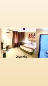 a hotel room with a bed and a television at Laxston Hotel in Yogyakarta