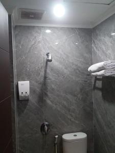 a bathroom with a shower with a toilet in it at Laxston Hotel in Yogyakarta