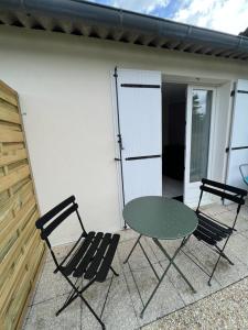 a table and two chairs on a patio at Chez Laurie et Xavier studio 2 in Mignaloux-Beauvoir