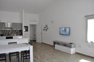une cuisine avec des murs blancs et une table et des chaises dans l'établissement Residenza Benvenuto Cellini, à La Maddalena