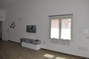 une pièce blanche avec une fenêtre et une table dans l'établissement Residenza Benvenuto Cellini, à La Maddalena