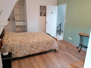a small bedroom with a bed and a staircase at Gîtes Ferme de la Courbée in Cherbourg en Cotentin