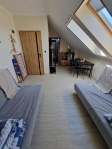 a attic room with two beds and a dining room at Rewa Morska 103 in Rewa