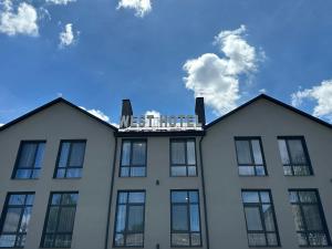 MostiskaWest Hotel的白色的建筑,上面有标志