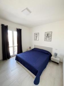 una camera da letto con un letto blu e una finestra di Affittimoderni La Maddalena - MADA22 a La Maddalena