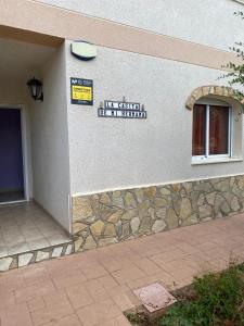a building with a sign on the side of it at La casita de mi hermana in Miami Platja