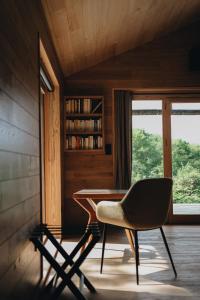 ein Tisch und ein Stuhl in einem Zimmer mit Fenster in der Unterkunft BANDIAT Le Domaine in Fargeas