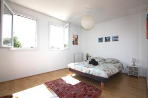 una camera da letto con un letto e due finestre di Maison 2 chambres avec jardin et piscine a La Teste-de-Buch