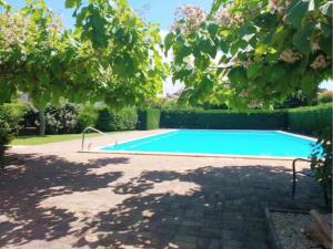 una piscina in un cortile alberato di Maison 2 chambres avec jardin et piscine a La Teste-de-Buch
