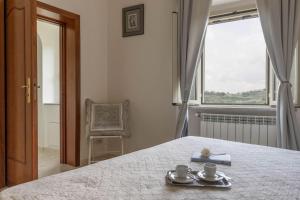 a bedroom with a bed with two cups and a window at Casa Il Fico in Usigliano