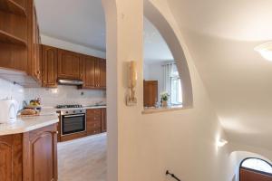 a kitchen with wooden cabinets and an archway at Casa Il Fico in Usigliano +28 photos