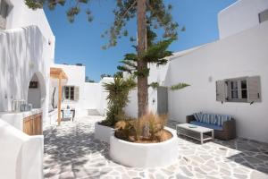 a courtyard with a tree in a white building at Swell S11 new studio in Naousa in Naousa