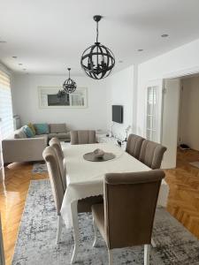a dining room with a white table and chairs at Luxury 2 Apartment in Bijelo Polje