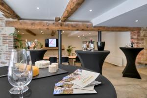 a table with a glass of wine and cheese on it at CHATEAU LAURIGA in Thuir