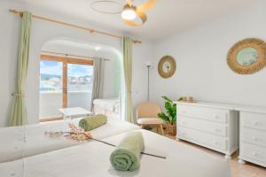 a white bedroom with a bed and a mirror at Beautiful 4 bedroom house with phenomenal golf and mountain views in San Miguel de Abona