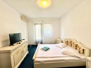 a white bedroom with a bed and a television at Sunsilva in Olimp +32 photos