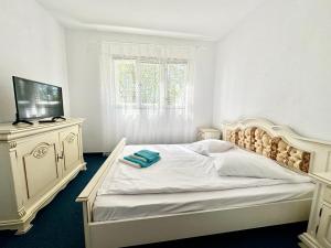 a white bedroom with a bed and a dresser at Sunsilva in Olimp