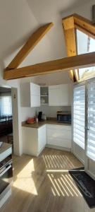 Il comprend une cuisine avec des placards blancs et du parquet. dans l'établissement Maison l'EscaleTaussat Les Bains, à Lanton