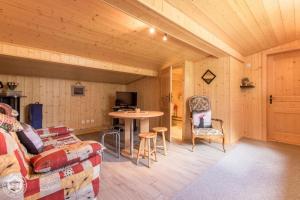 a living room with a couch and a table at Le Balcon de Novel - Chalet en pleine nature in Novel