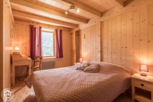 a bedroom with a bed and a desk and a window at Le Balcon de Novel - Chalet en pleine nature in Novel