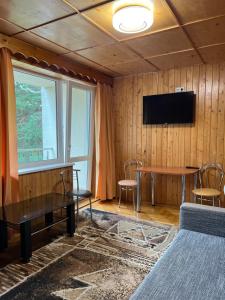 een kamer met een tafel en een tv aan de muur bij Cunami in Nida