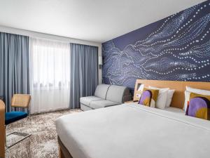 a hotel room with a bed and a couch at Novotel Paris Charenton le Pont in Charenton-le-Pont