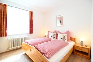 a bedroom with a bed with pink sheets and a window at Ferienhaus JOLOISIA mit Blick auf Planai in Schladming +30 photos