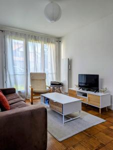 un salon avec un canapé et une télévision dans l'établissement Magnifique T1 bis à proximité de Paris, à Fontenay-aux-Roses