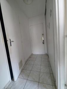 - un couloir avec une porte blanche et du carrelage dans l'établissement Magnifique T1 bis à proximité de Paris, à Fontenay-aux-Roses 1 autre photo