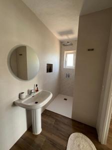 a white bathroom with a sink and a mirror at Villa tosalet in Jávea