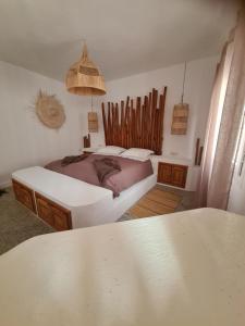 a bedroom with two beds and a table at La Maison des Vagues in Sidi Kaouki