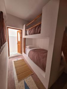 a bedroom with two bunk beds and a window at La Maison des Vagues in Sidi Kaouki