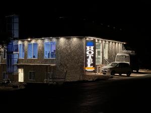 锡卡都Nestopia Hotel - Skardu的晚上停在建筑物前的汽车