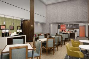a restaurant with tables and chairs and a counter at Hampton Inn & Suites Orlando North Altamonte Springs in Orlando