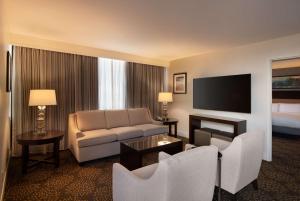 a hotel room with a couch and a television at DoubleTree by Hilton Washington DC – Crystal City in Arlington