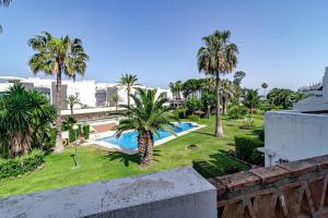 a view of a resort with a swimming pool and palm trees at PG9 - Andalucian 3-story townhouse near Estepona in Estepona