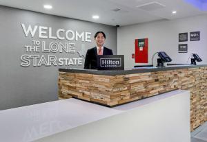 a man is standing at a welcome to the lone star state at Hampton Inn Houston-Pearland, TX in Pearland