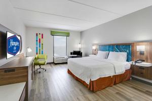 a hotel room with a large bed and a desk at Hampton Inn Houston-Pearland, TX in Pearland