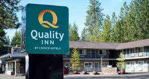 Un cartel que anuncia una posada de calidad frente a un edificio. en Quality Inn South Lake Tahoe, en South Lake Tahoe