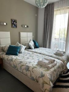 Un dormitorio con dos camas con almohadas y una ventana. en Apartment in Paradise View complex, en Sozopol