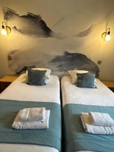 two beds with towels on them in a room at Le Dahu in Chamonix-Mont-Blanc