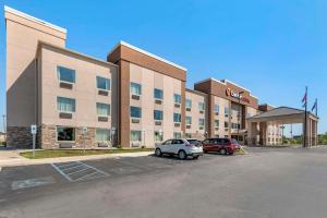 a hotel with two cars parked in a parking lot at Comfort Suites Fort Wayne - Southwest in Fort Wayne