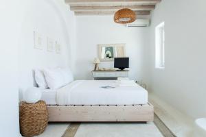 biała sypialnia z łóżkiem i stołem w obiekcie Villa Jasper by Mykonos Stays w mieście Mykonos
