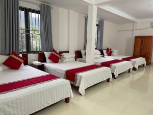 a group of four beds in a room at Thành Luân Hotel in Bak Kan
