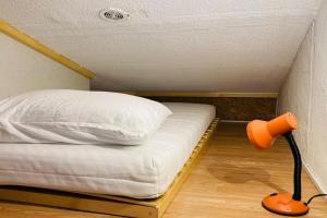 un petit lit dans une petite pièce avec une lampe dans l'établissement Résidence au bord de l étang de Thau, à Marseillan