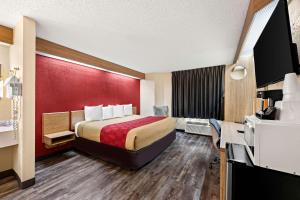 una camera d'albergo con letto e parete rossa di Econo Lodge London North a London Altre 22 foto
