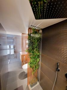 a bathroom with a toilet and plants on the wall at AlpenblickStudio-at Views of the Alps, Gym and Sauna in Brittenberg