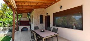 a patio with a table and a fireplace at Luxury Villa konstantina! in Yerakiní